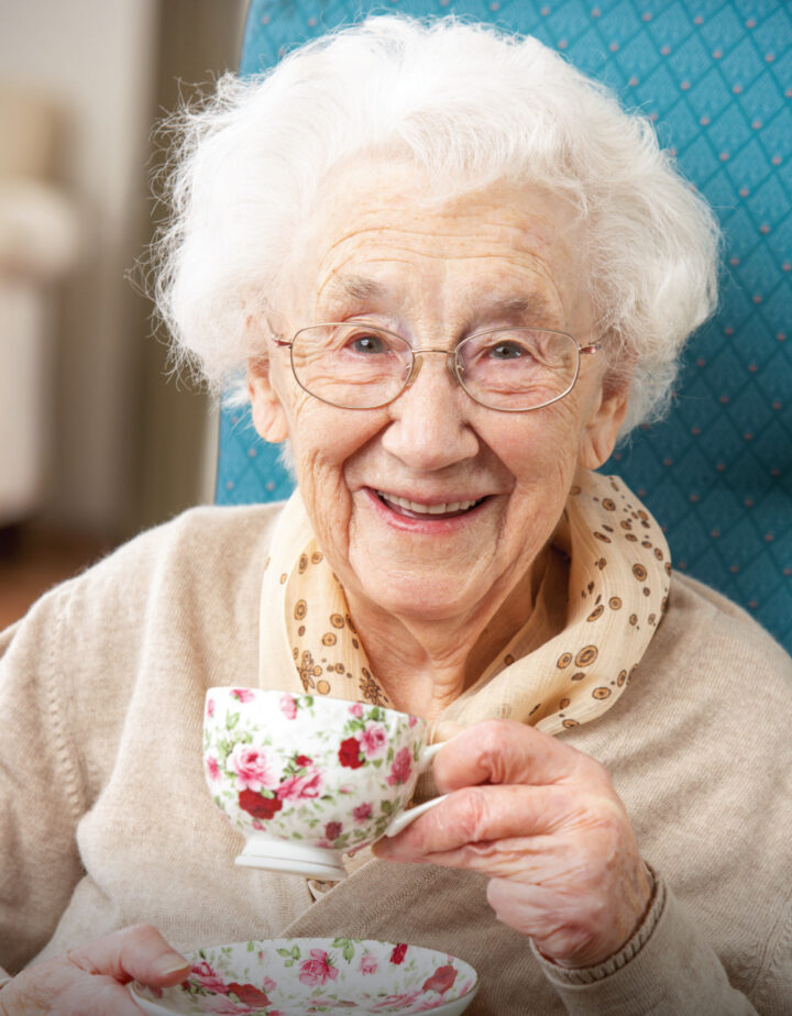 Happy senior woman sipping a warm cup of tea