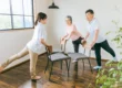 Caregiver leading seniors in chair exercises