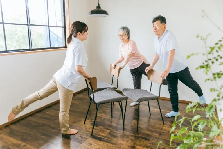 Caregiver leading seniors in chair exercises